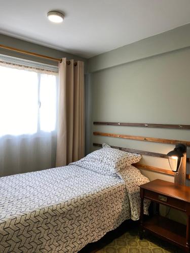 a bedroom with a bed and a table and a window at Container convertido en acogedor apartamento in Cajicá