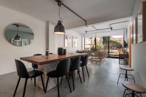 a dining room with a wooden table and chairs and a mirror at Homey 2BR in Roma Norte in Mexico City