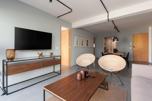 a living room with a tv and two chairs and a table at Homey 2BR in Roma Norte in Mexico City