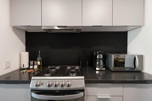 a kitchen with a stove and a microwave at Homey 2BR in Roma Norte in Mexico City