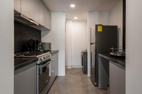 a kitchen with a stove and a refrigerator at Homey 2BR in Roma Norte in Mexico City