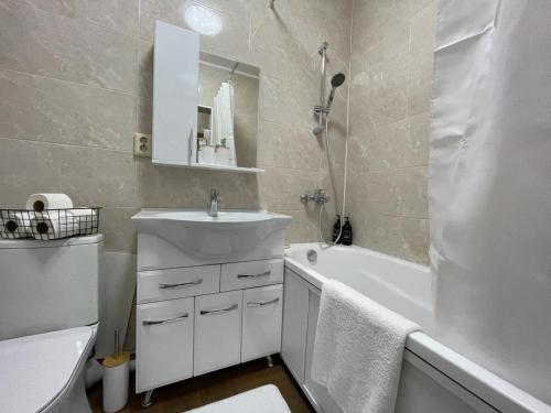 een badkamer met een wastafel, een bad en een toilet bij Студия Свежесть в центре города in Alma-Ata