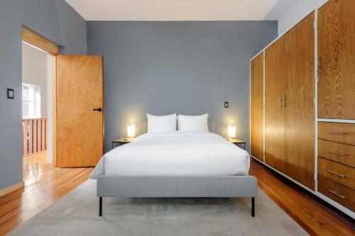 sypialnia z dużym białym łóżkiem i drewnianymi szafkami w obiekcie Perfect 3BR Duplex in Cuauhtemoc w mieście Meksyk