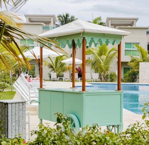 a table with an umbrella next to a swimming pool at Exclusive Villa * private Beach and Housekeeping in Punta Cana
