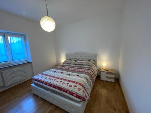 a bedroom with a bed with a red and white blanket at Apartment Weisswand in Colle Isarco