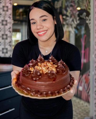 a woman holding a chocolate cake with nuts on it at Exclusive Villa * private Beach and Housekeeping in Punta Cana