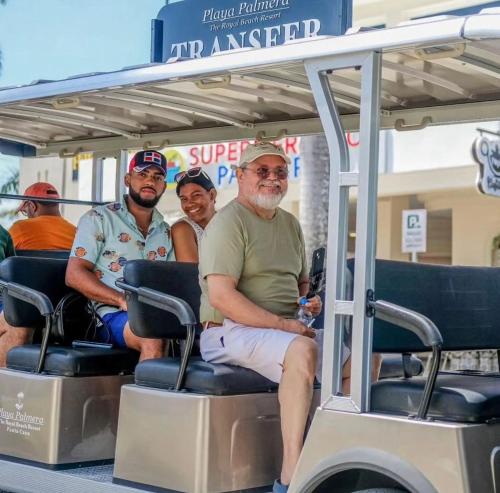 a group of men riding on a golf cart at Exclusive Villa * private Beach and Housekeeping in Punta Cana