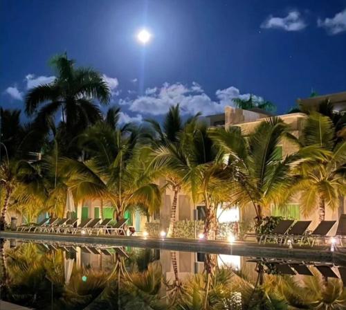 a hotel with palm trees and a pool at night at Exclusive Villa * private Beach and Housekeeping in Punta Cana