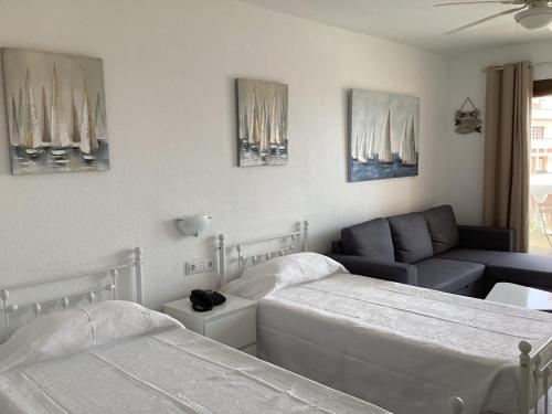 a bedroom with two beds and a couch at Estupendo Estudio en Castle Harbour Los Cristianos in Los Cristianos