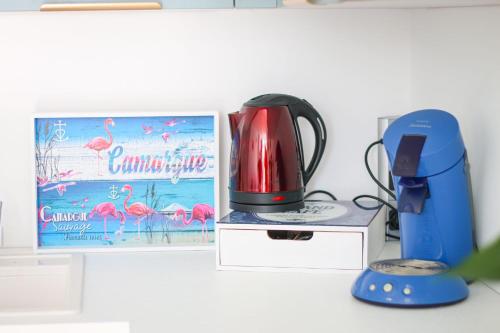 une cafetière assise à côté d'une boîte dans l'établissement Les Appartements De Lina - Appartement Poseidon - Self Check-In -, à La Grande Motte