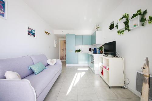 un salon avec un canapé et une cuisine dans l'établissement Les Appartements De Lina - Appartement Poseidon - Self Check-In -, à La Grande Motte