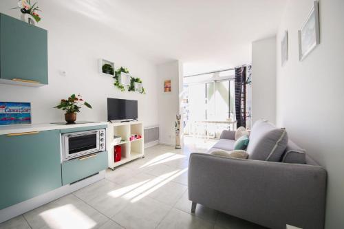 un salon avec un canapé et une télévision dans l'établissement Les Appartements De Lina - Appartement Poseidon - Self Check-In -, à La Grande Motte