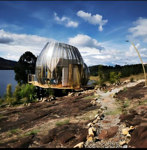 una casa en la cúpula al lado de un cuerpo de agua en Guatavita Glamping club, en Bogotá