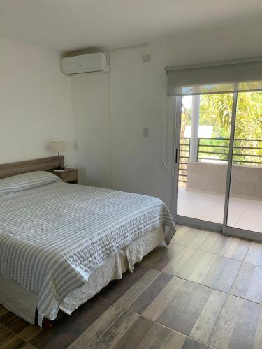 a white bedroom with a bed and a sliding glass door at Rio Victoria in Victoria