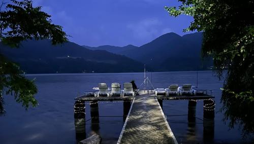 a dock with a group of chairs on the water at Orsova Gratca 164 in Orşova