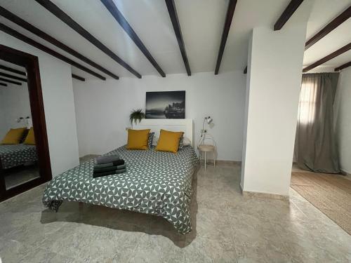 1 dormitorio con 1 cama con almohadas amarillas en YucaJaus, en Teguise