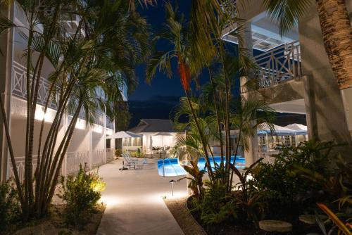 een resort met een zwembad en palmbomen in de nacht bij South Point Hotel in Christ Church