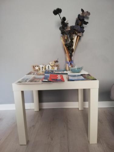 a white table with a vase and flowers on it at Casa Vacanze Mariposa in Trieste