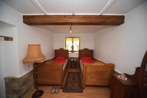 um pequeno quarto com 2 camas e uma janela em Salaš Trikić em Aleksandrovo