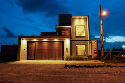 a house with a garage at night at Canto da Nega - Seu canto na Praia! in Itapoa