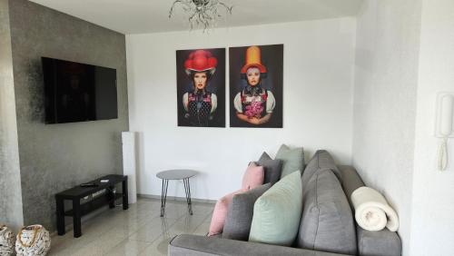 a living room with a couch and pictures on the wall at Gästehaus Ferienwohnung Abendstern in Rust