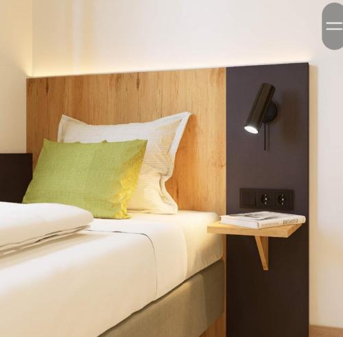 a bedroom with a bed with a wooden headboard at Motel Sleep Inn in Töging am Inn