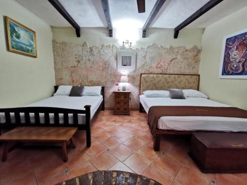 a bedroom with two beds and a table in it at Boutique Colonial House Hotel in Santo Domingo