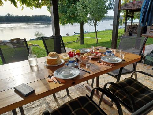a table with food on it with a view of the water at Kuća za odmor Takač in Batina