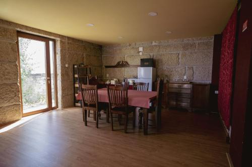 uma cozinha e sala de jantar com mesa e cadeiras em Casa dos Primos em Muxagata