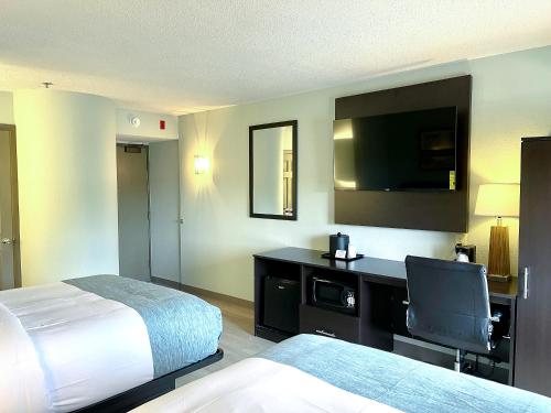 a hotel room with a bed and a flat screen tv at Wingate by Wyndham Salisbury in Salisbury