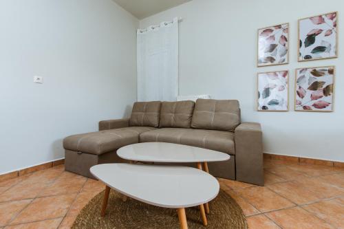 a living room with a couch and two tables at Ellafos Traditional Living in Loúkhiou