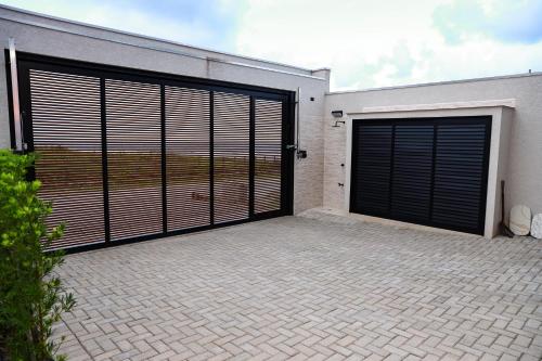 two garage doors on the side of a building at Canto da Nega - Seu canto na Praia! in Itapoa