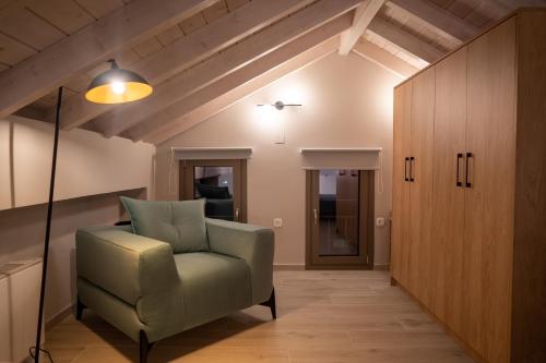 a living room with a green chair and wooden ceilings at Akti Vigla Apartments in Mytilini