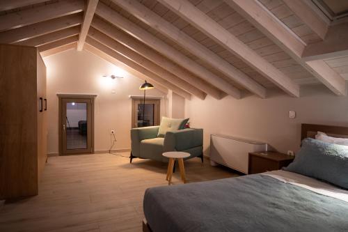 a bedroom with a bed and a couch and a chair at Akti Vigla Apartments in Mytilini