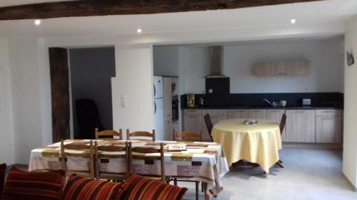 une salle à manger avec une table et des chaises et une cuisine dans l'établissement GITE de la GAUMERAIS, à Chèvreville