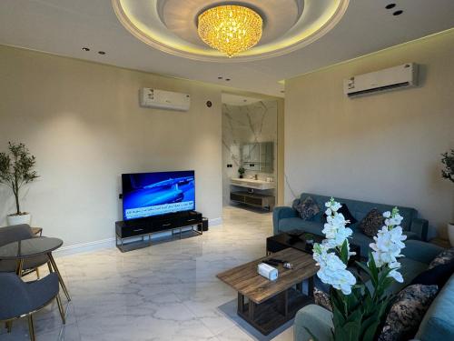 salon z niebieską kanapą i telewizorem w obiekcie شقة ارضية فاخرة ٣ غرف وصالة دخول ذاتي ٧ w Rijadzie