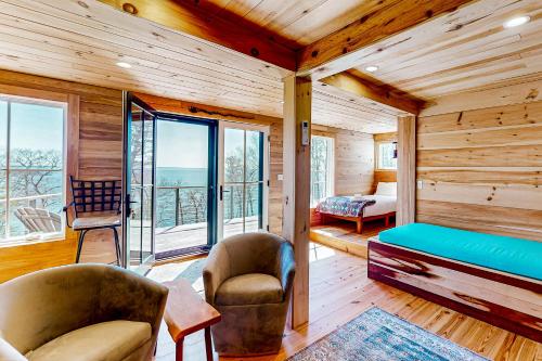 a room with a bed and chairs in a room with wooden walls at Cottage on the Coast in Rockport