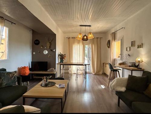 a living room with a couch and a table at La glycine in Saint-Marc-Jaumegarde