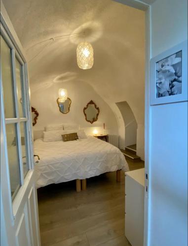 une chambre avec un lit blanc dans une pièce dans l'établissement La glycine, à Saint-Marc-Jaumegarde