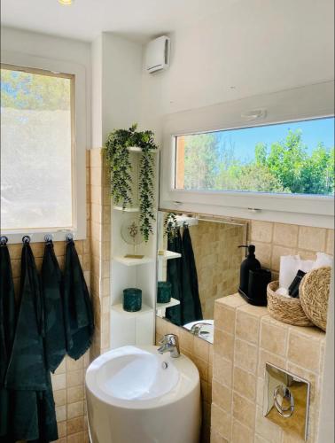 une salle de bain avec un lavabo et une fenêtre dans l'établissement La glycine, à Saint-Marc-Jaumegarde