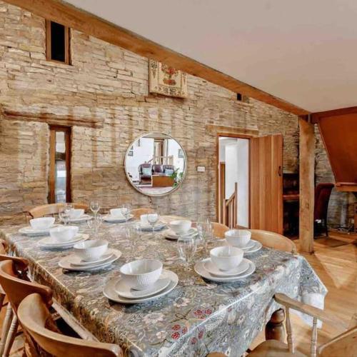 a table with plates and cups and a mirror at Cosy luxury Grade II listed barn in the Forest of Dean in Westbury on Severn