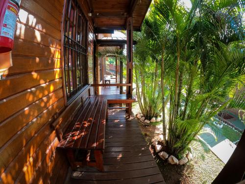 a porch of a house with benches and palm trees at Terra Iguazú Cabañas in Puerto Iguazú