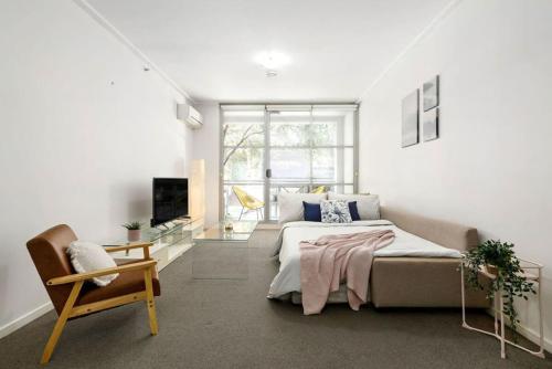a bedroom with a large bed and a chair at A Modern & Cozy Studio Next to Darling Harbour in Sydney