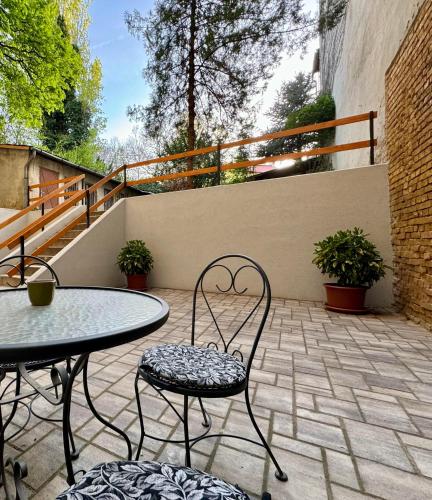 a patio with a table and chairs and a fence at Kleh Residence in Budapest