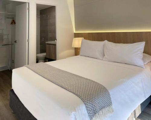 1 cama blanca grande en una habitación pequeña en Comfortable 1BR with modern balcony in San Isidro en Lima