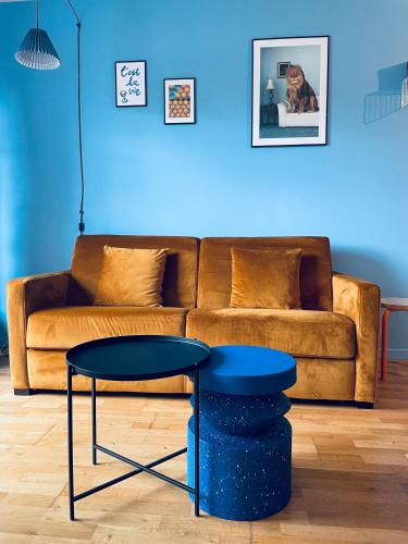 a blue living room with a couch and a stool at Be My Guest - Proche Disneyland Paris in Quincy-Voisins