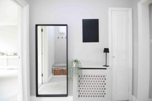 a mirror in a white room with a sink at Beautiful Top Floor Clifton Apartment in Bristol