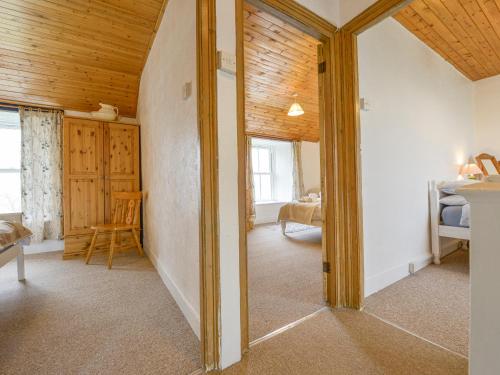 a room with a wooden ceiling and a bedroom at The Farmhouse in Penzance