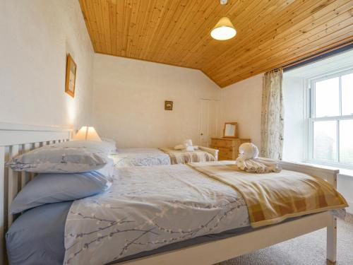 a bedroom with two beds and a window at The Farmhouse in Penzance