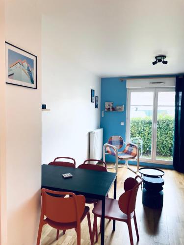 une salle à manger avec une table et des chaises bleues dans l'établissement Be My Guest - Proche Disneyland Paris, à Quincy-Voisins